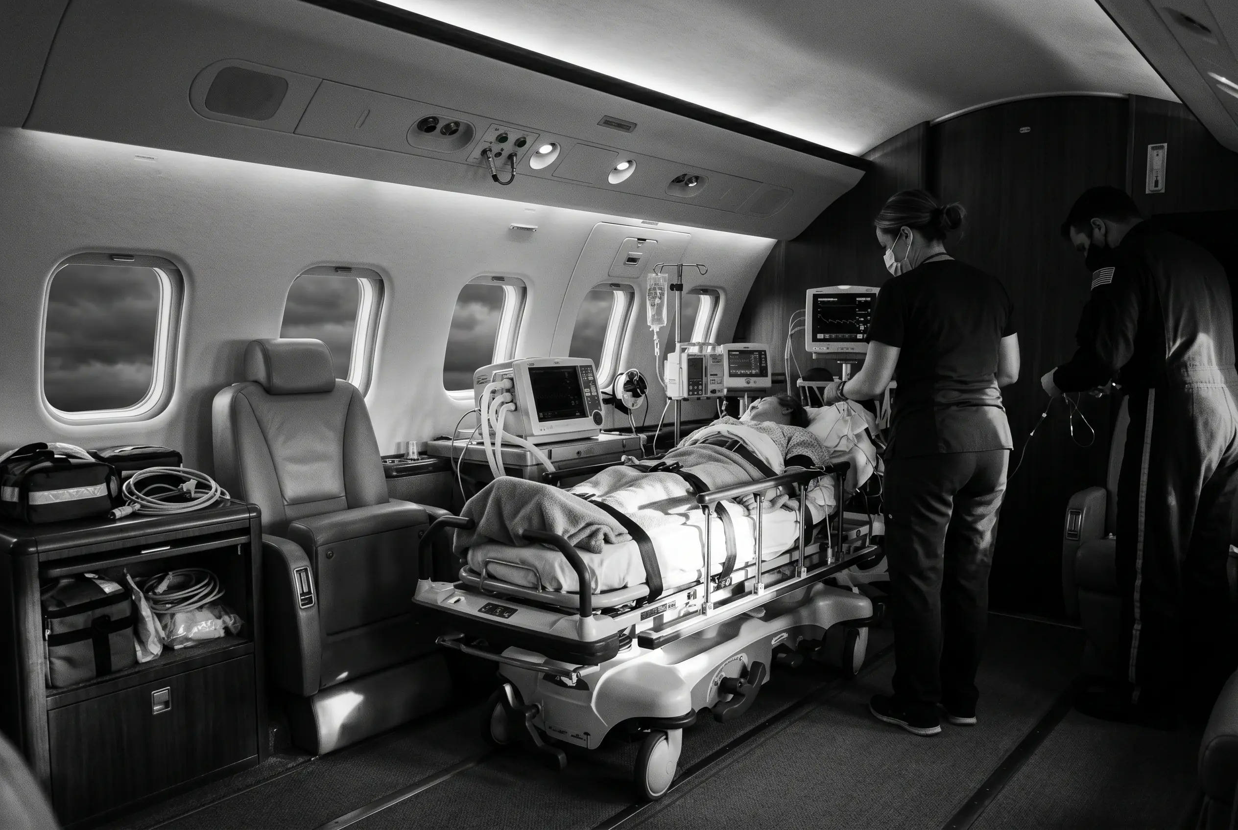 Medically-equipped private jet interior for patient transport between New York and Miami, in monochrome