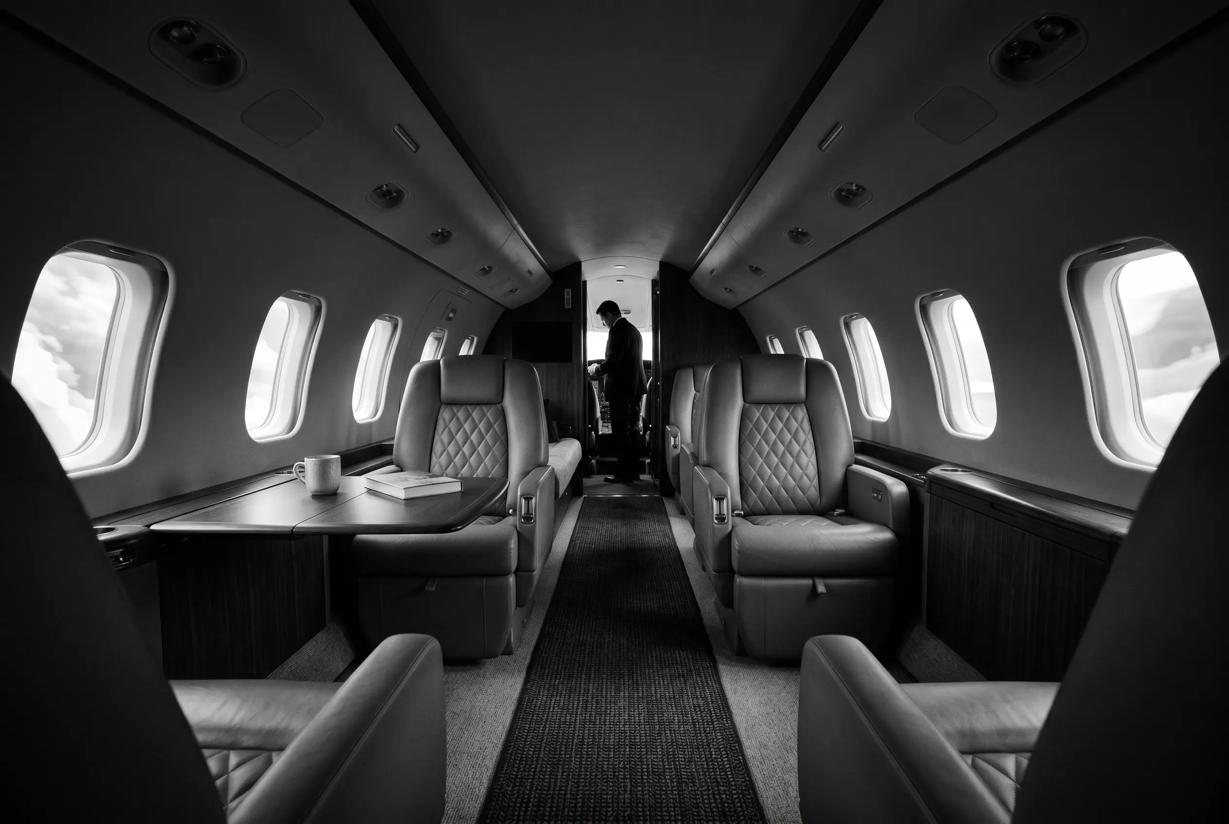 Bombardier Challenger 300 wide flat-floor cabin for a New York to Miami charter, in monochrome