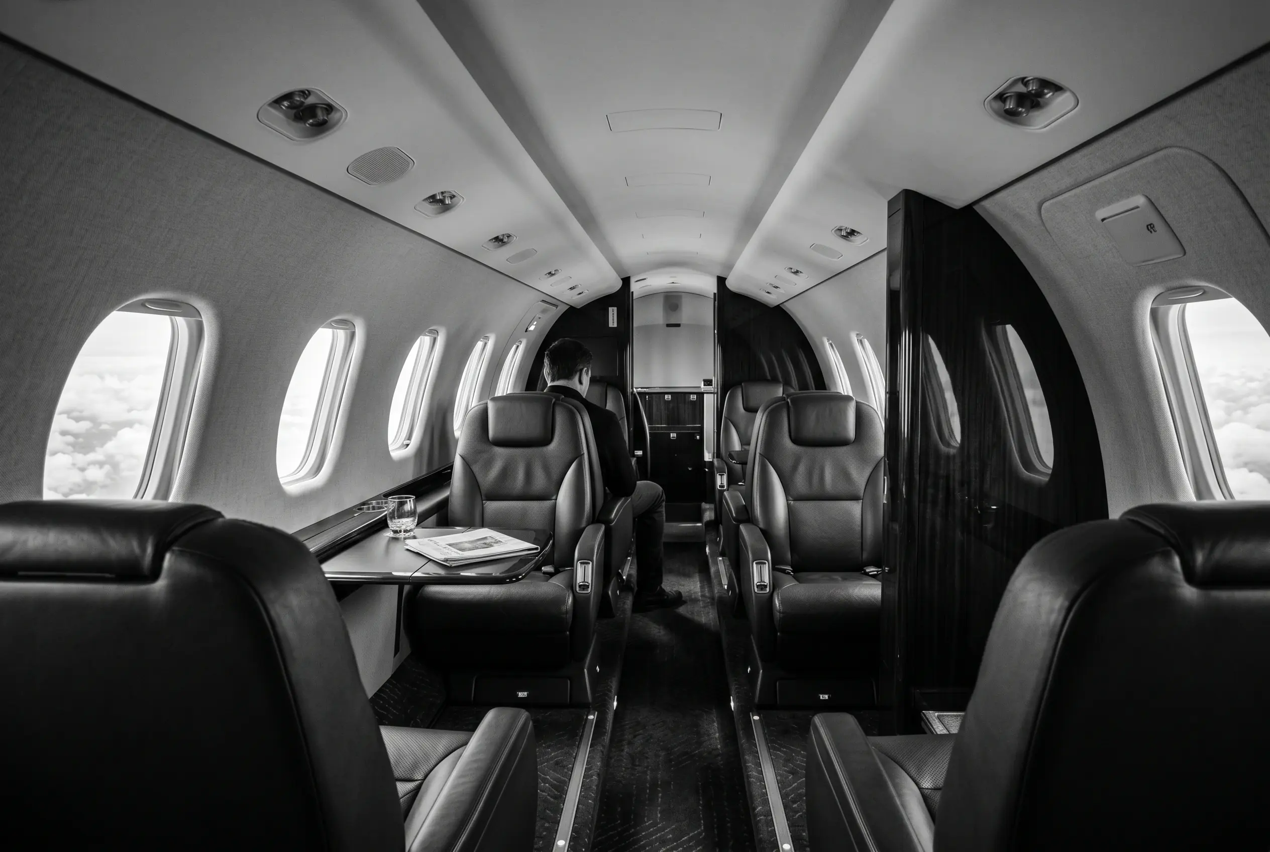 Cessna Citation Sovereign+ long stand-up cabin for a New York to Miami charter, in black and white