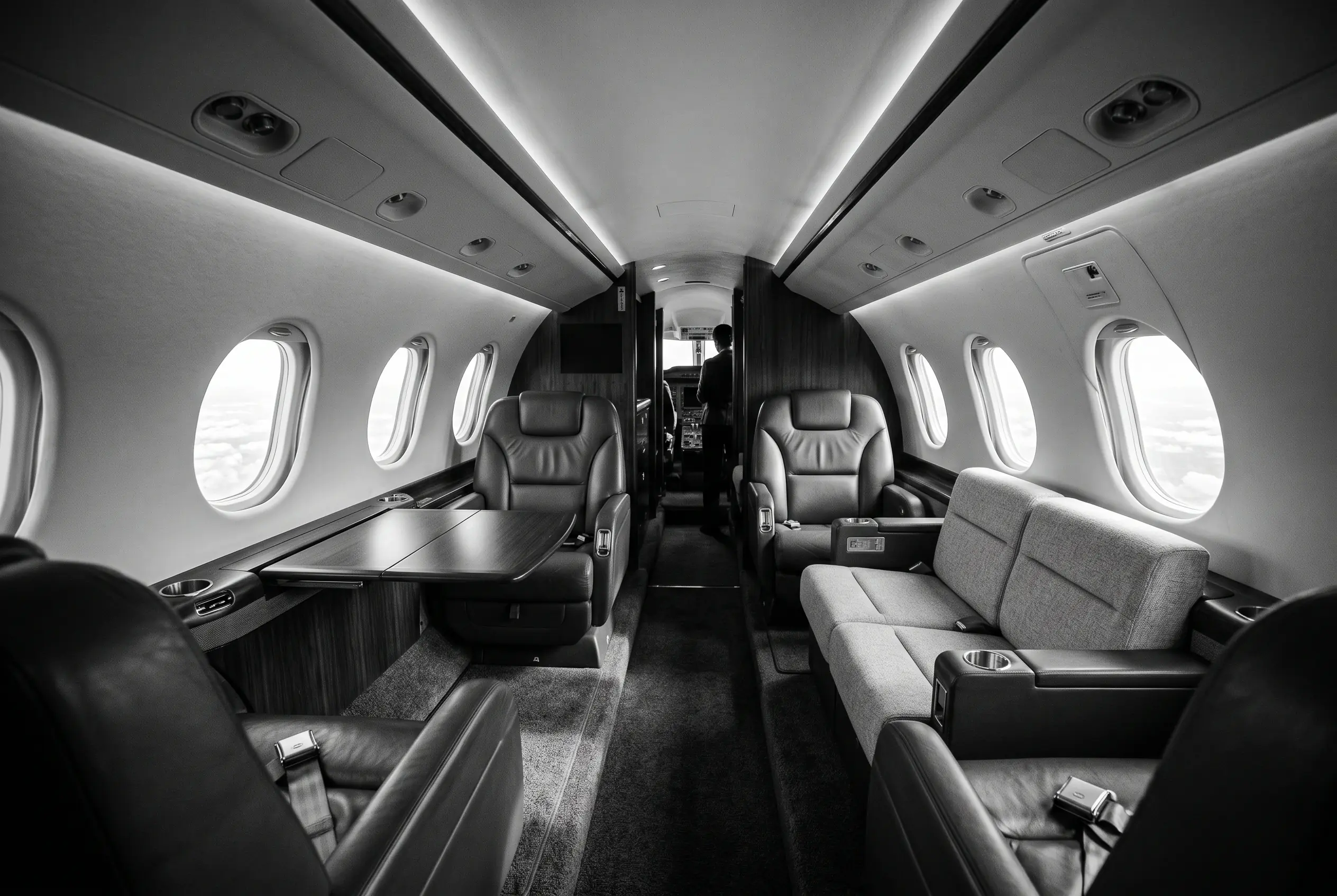 Hawker 900XP wide flat-floor cabin for a New York to Miami charter, in monochrome