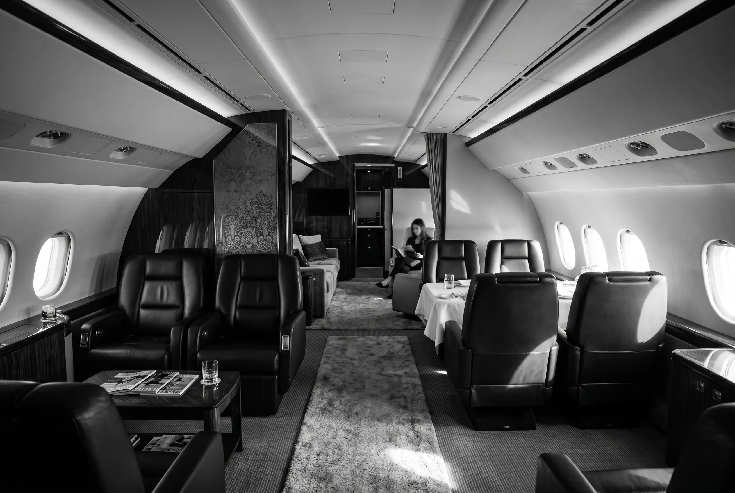 Large heavy jet cabin with multiple living zones for a New York to Miami charter, in black and white