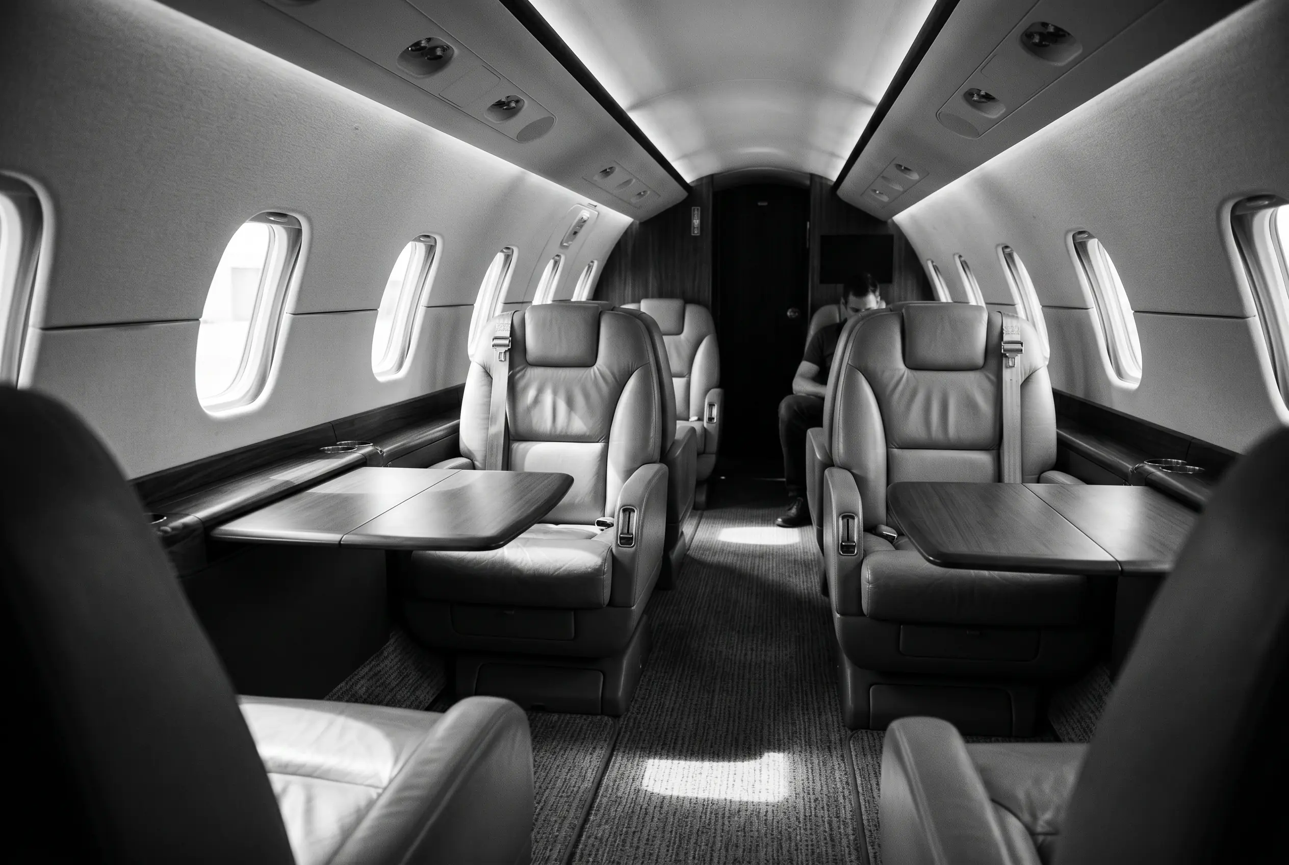 Light jet cabin in club configuration for a New York to Miami charter, in monochrome