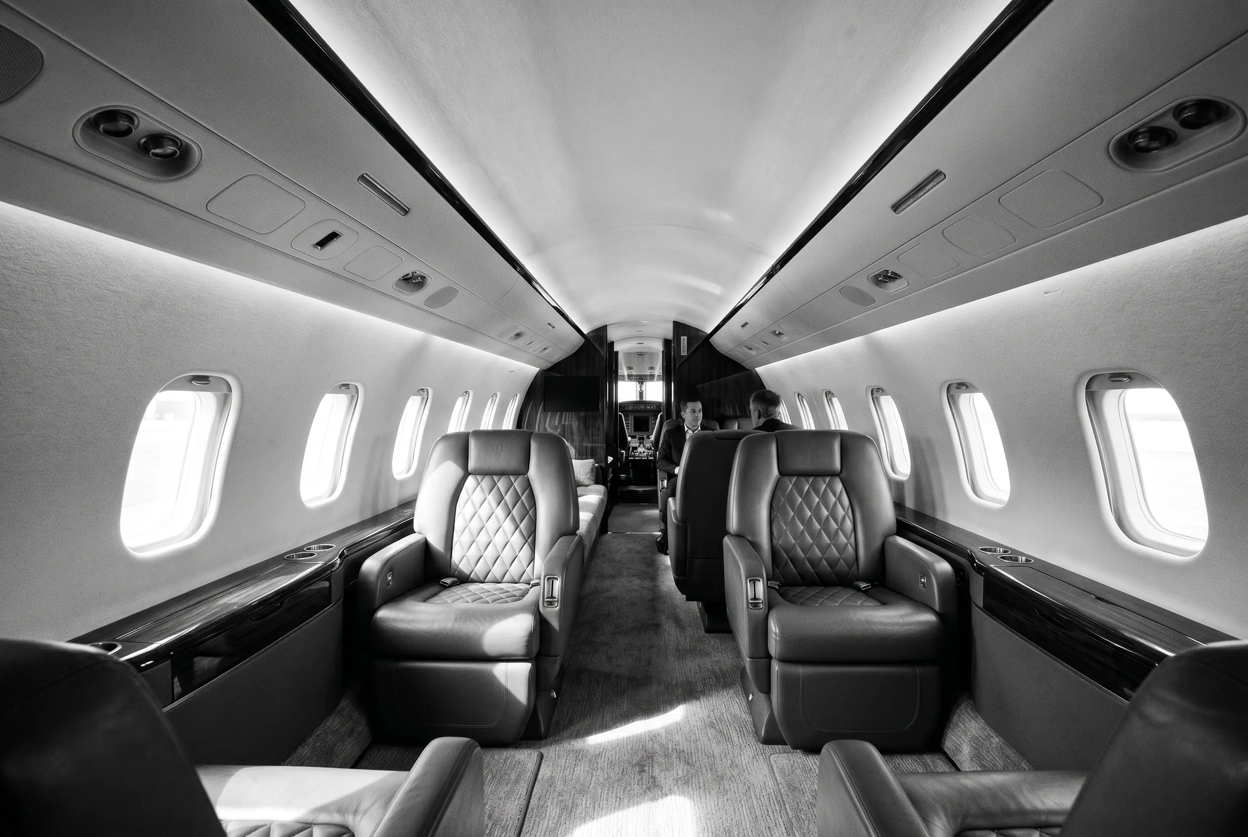 Midsize jet cabin with full standing height for a New York to Miami charter, in black and white