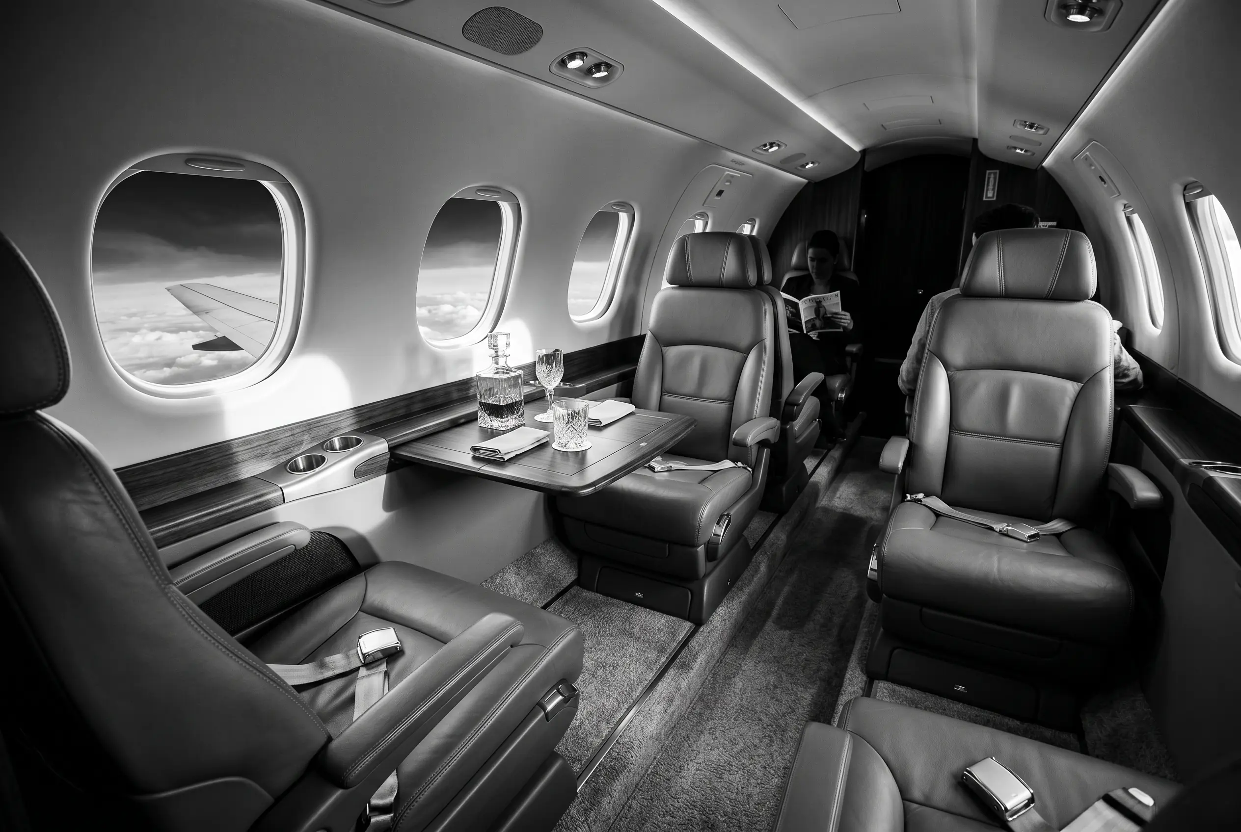 Embraer Phenom 300E club cabin for a New York to Miami charter, in monochrome